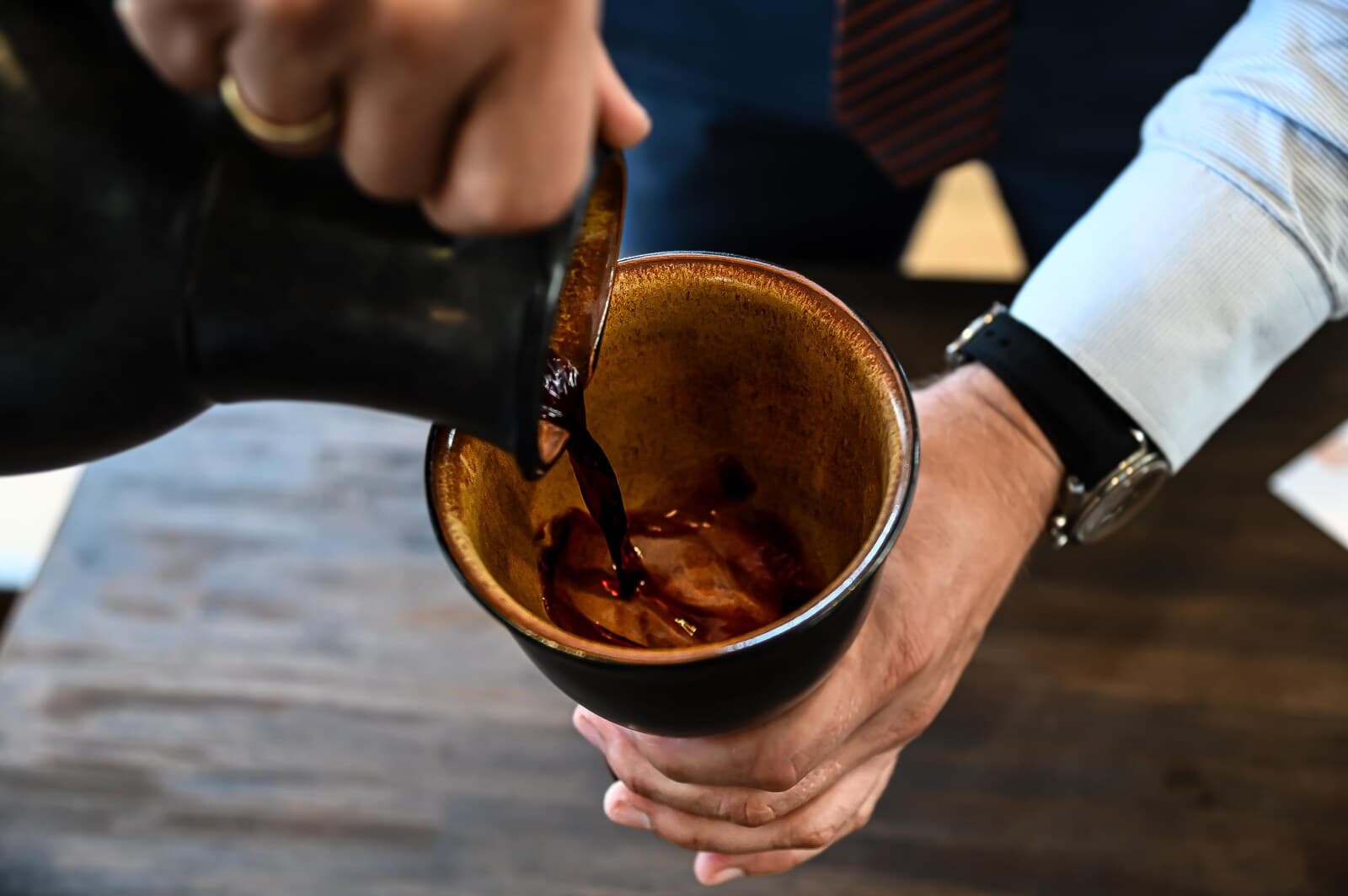 Wein wird aus einer Kanne in einen Becher gegossen